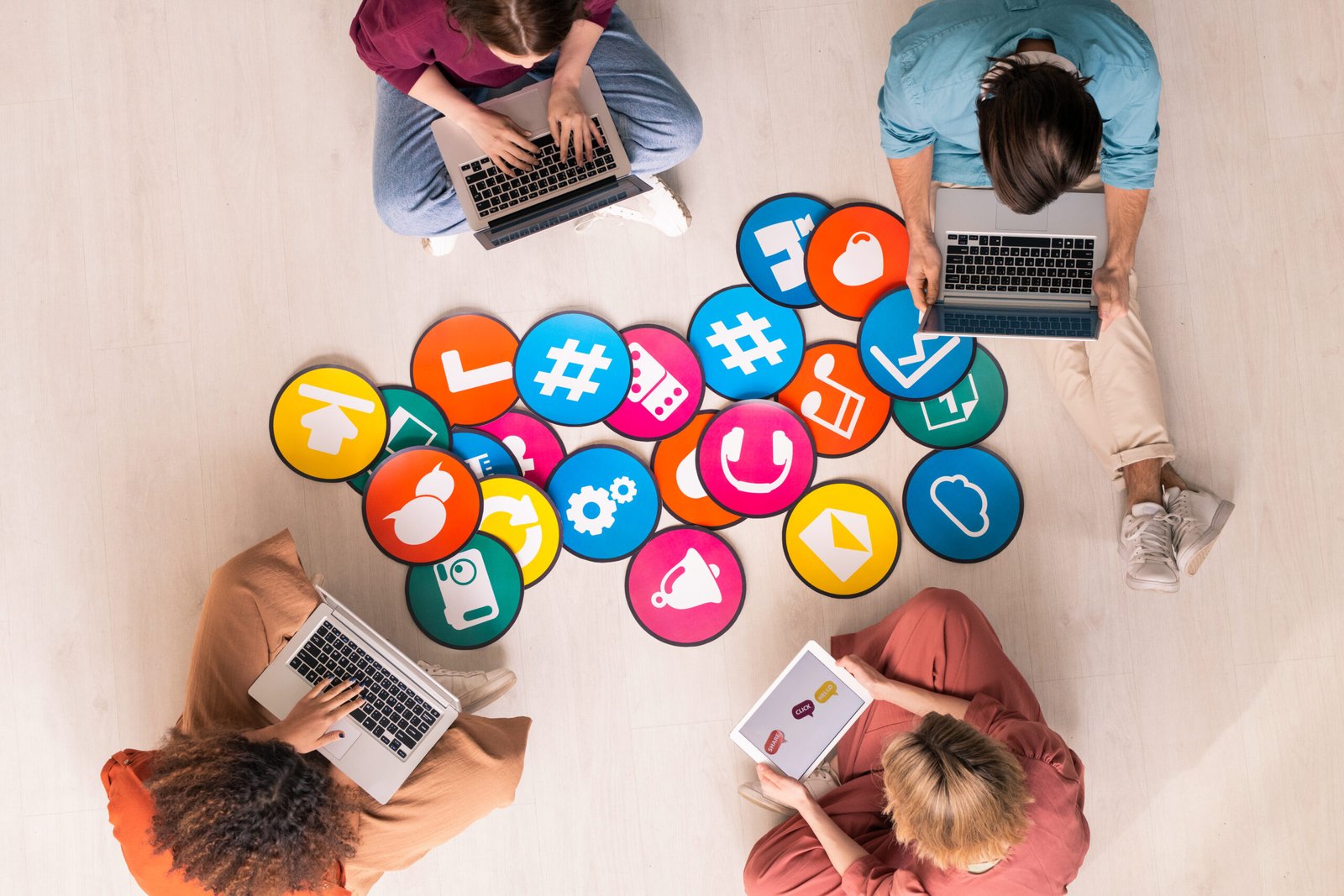 Young friendly people in casualwear sitting by multi-color papers with icons YouTube promotion service
